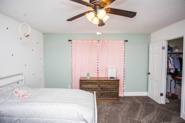 carpeted bedroom featuring a walk in closet, a closet, and ceiling fan