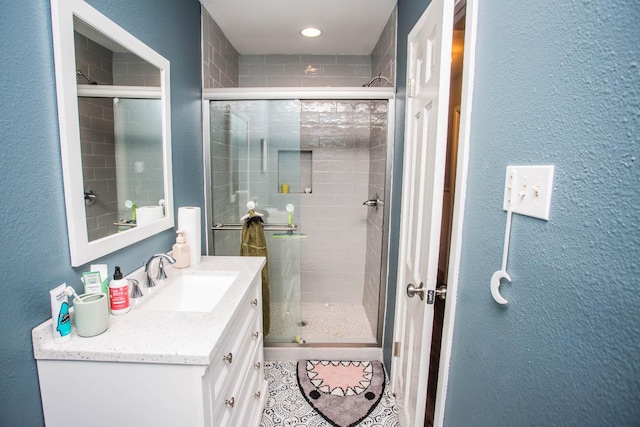 bathroom with vanity and a shower with shower door