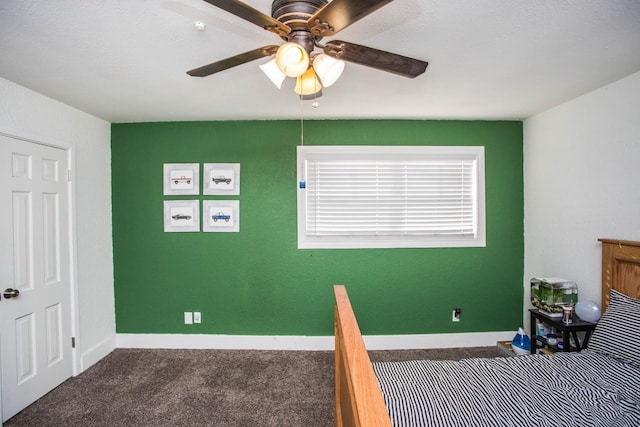 unfurnished bedroom with ceiling fan and dark carpet