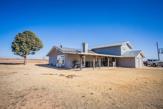 rear view of house featuring a garage and a patio