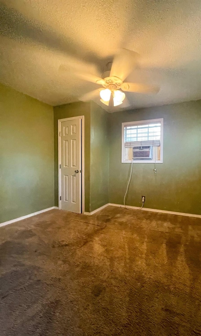 unfurnished room featuring a textured ceiling, carpet floors, cooling unit, and baseboards