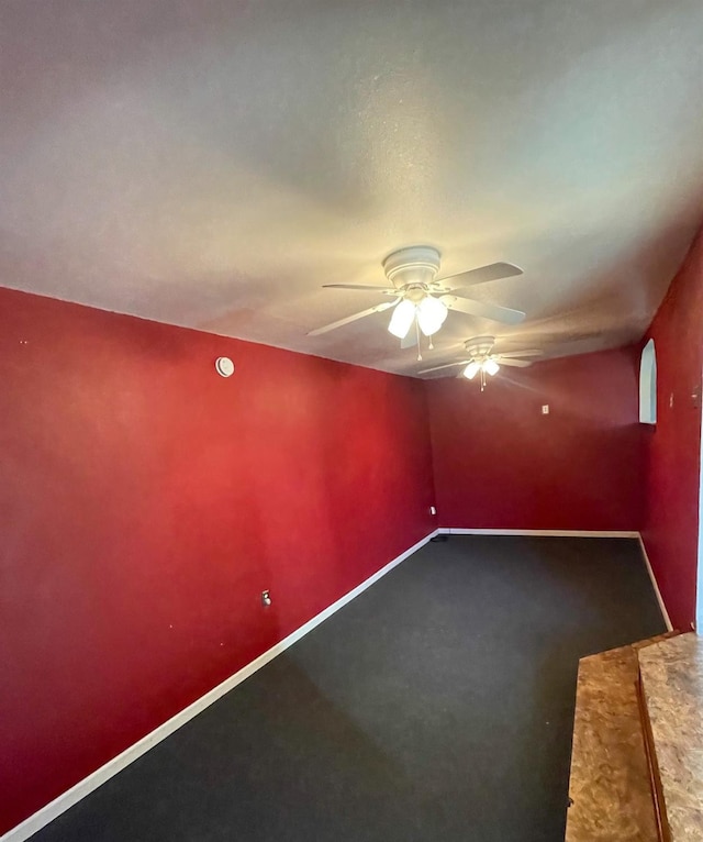 spare room with ceiling fan, baseboards, and carpet flooring