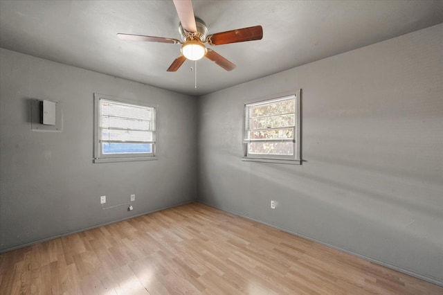 empty room featuring ceiling fan, a healthy amount of sunlight, and light hardwood / wood-style floors