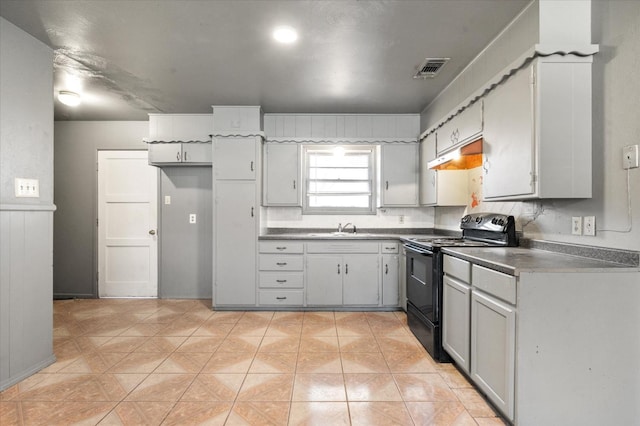 kitchen featuring gray cabinetry, black range with electric stovetop, light tile patterned floors, and sink