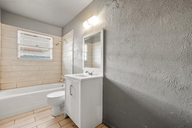 full bathroom with vanity, tiled shower / bath, and toilet