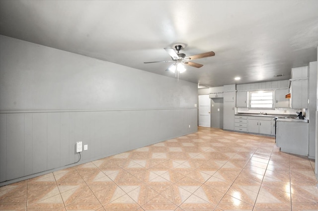 kitchen with gray cabinets, sink, light tile patterned floors, and ceiling fan