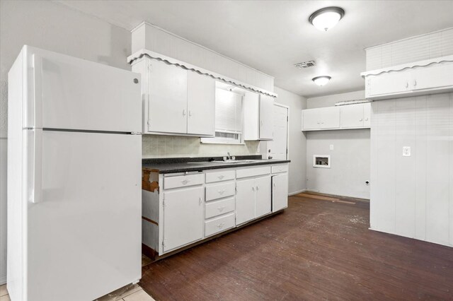 kitchen with dark hardwood / wood-style flooring, sink, white fridge, and white cabinets