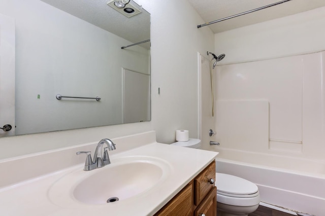 full bathroom with vanity, toilet,  shower combination, and a textured ceiling