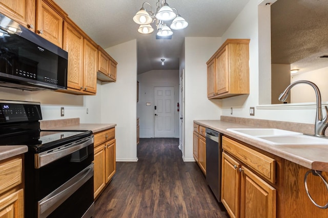 kitchen with sink, black appliances, a textured ceiling, dark hardwood / wood-style flooring, and decorative light fixtures