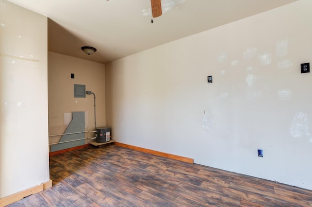 spare room with dark wood-type flooring, electric panel, and ceiling fan