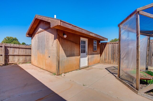 exterior space with an outdoor structure and a patio area