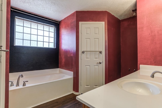 bathroom with vanity, a bathtub, a textured ceiling, and hardwood / wood-style flooring