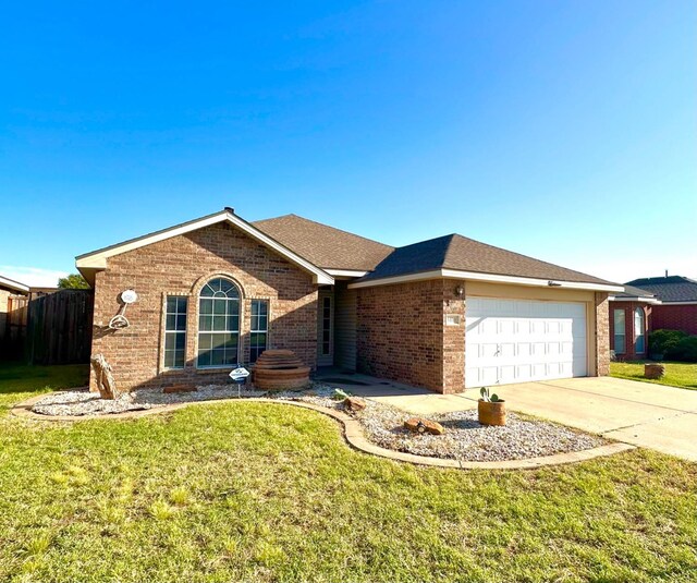 single story home featuring a garage and a front yard