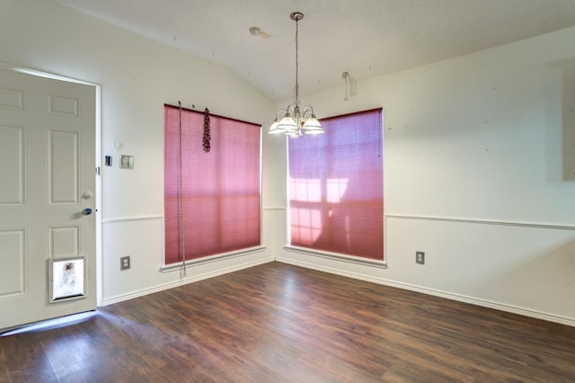 unfurnished dining area with dark wood-type flooring, a chandelier, and vaulted ceiling