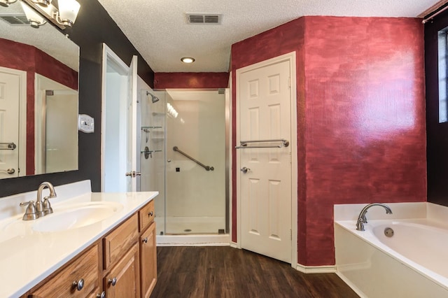 bathroom featuring vanity, plus walk in shower, hardwood / wood-style floors, and a textured ceiling