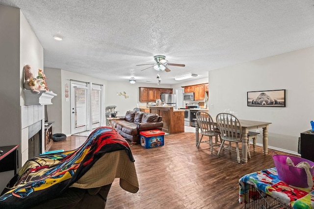 living room with ceiling fan, hardwood / wood-style floors, and a textured ceiling