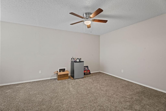 carpeted empty room with ceiling fan and a textured ceiling