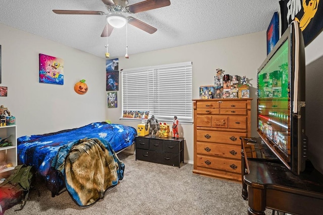 carpeted bedroom featuring ceiling fan and a textured ceiling