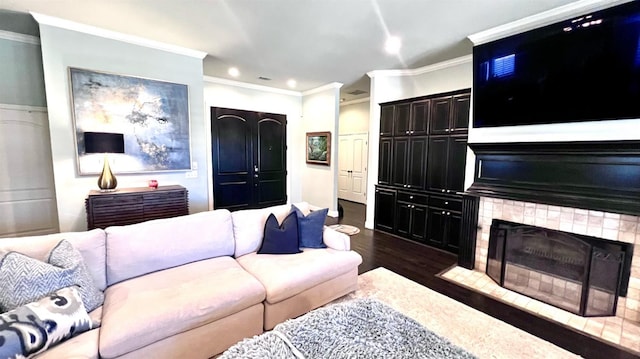 living room featuring dark hardwood / wood-style flooring, a fireplace, and ornamental molding