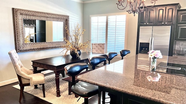 dining area featuring crown molding, dark hardwood / wood-style flooring, and a notable chandelier