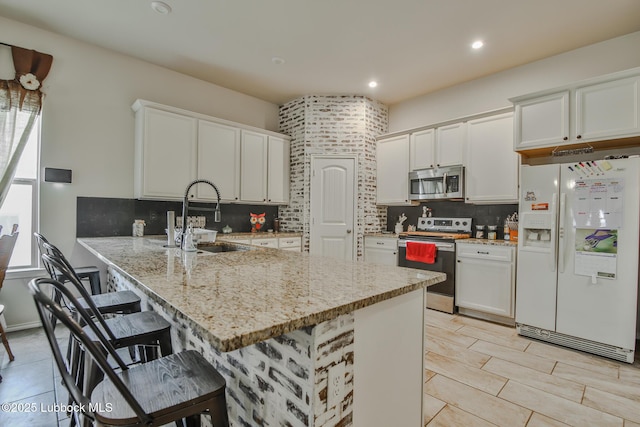 14320 Ave U, Lubbock, TX 79423 - kitchen featuring stainless steel appliances, a kitchen breakfast bar, a peninsula, decorative backsplash, and white cabinetry