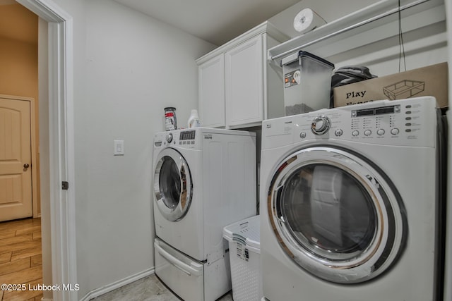 14320 Ave U, Lubbock, TX 79423 - washroom featuring washer and dryer, cabinet space, and light wood finished floors