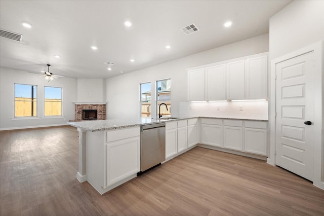 kitchen with white cabinetry, dishwasher, sink, and a wealth of natural light