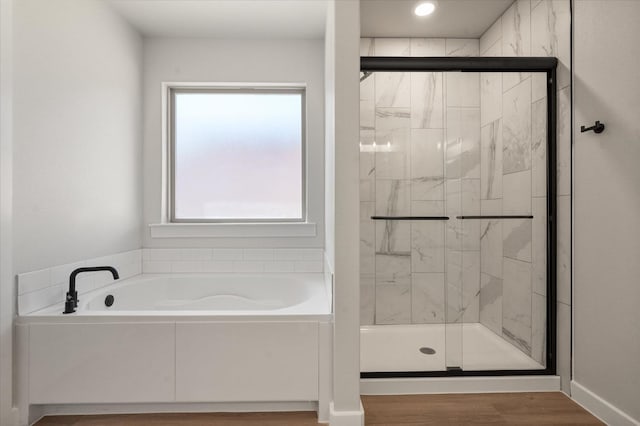 bathroom featuring hardwood / wood-style flooring and plus walk in shower