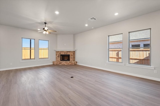 unfurnished living room with hardwood / wood-style flooring, a fireplace, and ceiling fan