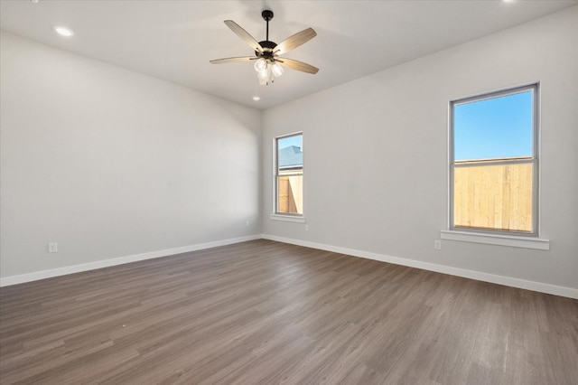 spare room with dark wood-type flooring and ceiling fan