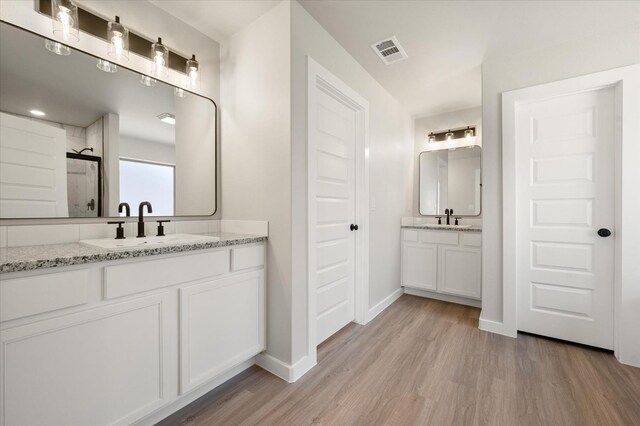 bathroom featuring vanity, a shower, and hardwood / wood-style floors