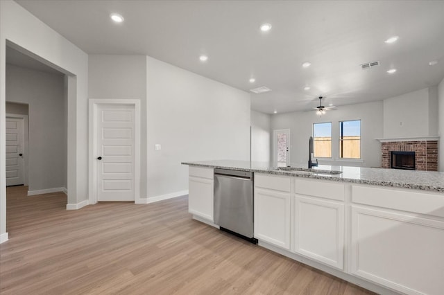 kitchen with sink, dishwasher, white cabinetry, light stone countertops, and light hardwood / wood-style floors