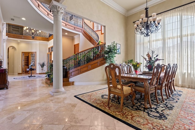 dining space featuring an inviting chandelier, ornamental molding, a high ceiling, and ornate columns