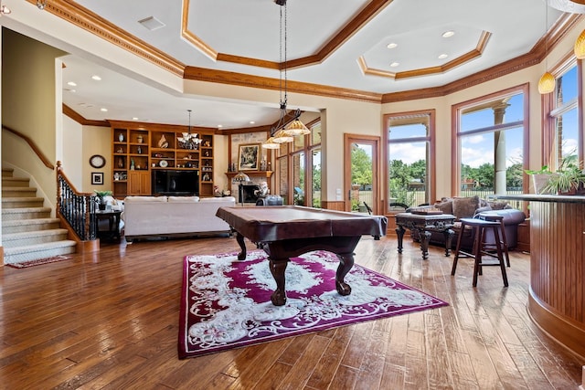 game room featuring a raised ceiling, wood-type flooring, ornamental molding, and billiards