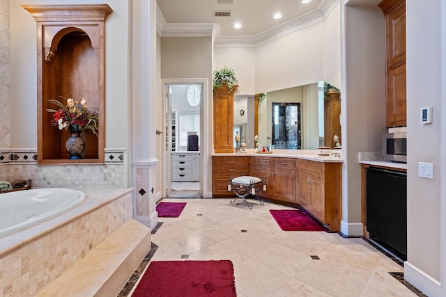 bathroom featuring tile patterned floors, ornamental molding, vanity, tiled bath, and a high ceiling