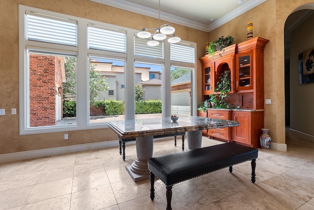 dining space with a high ceiling, ornamental molding, and an inviting chandelier