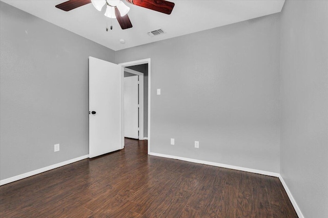 empty room with wood finished floors, visible vents, a ceiling fan, and baseboards