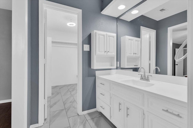 bathroom with baseboards, vanity, and marble finish floor