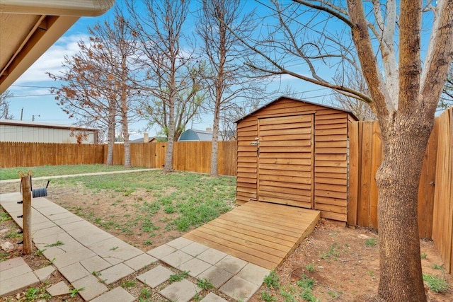 view of yard featuring a fenced backyard, an outbuilding, and a storage shed