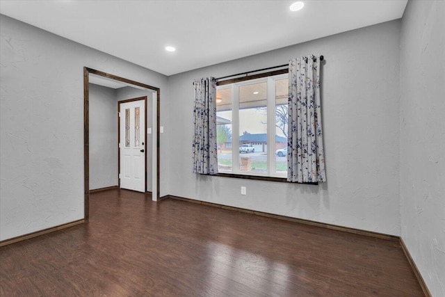 spare room featuring wood finished floors, recessed lighting, and baseboards