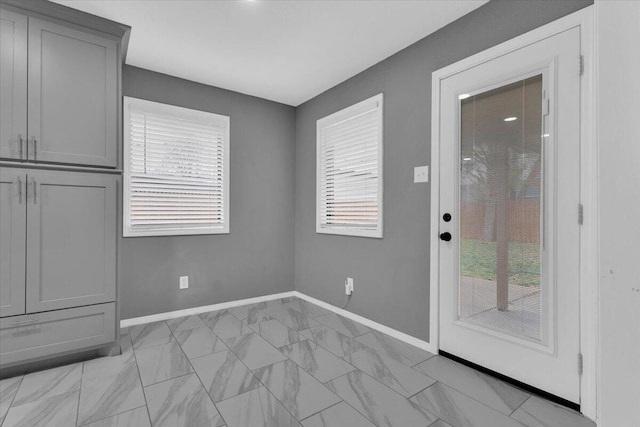 interior space featuring marble finish floor and baseboards
