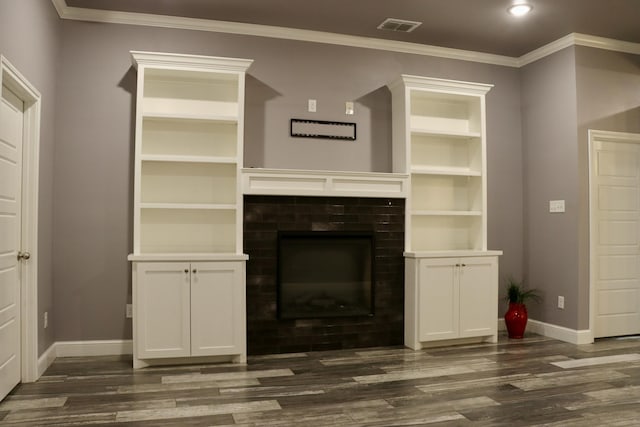 6952 24th St, Lubbock, TX 79407 - unfurnished living room with a tile fireplace, baseboards, dark wood-type flooring, ornamental molding, and built in shelves