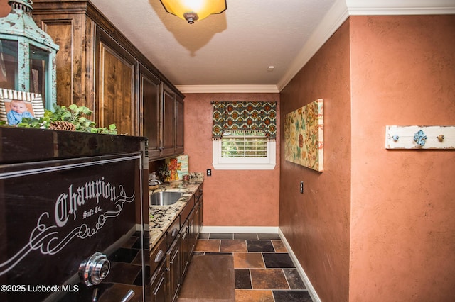 610 N 20th St, Lamesa, TX 79331 - bar with dark stone finish floors, a textured wall, and crown molding