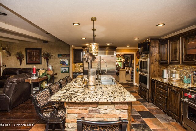 610 N 20th St, Lamesa, TX 79331 - kitchen with premium appliances, backsplash, dark brown cabinetry, and recessed lighting
