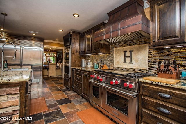 610 N 20th St, Lamesa, TX 79331 - kitchen featuring high end appliances, premium range hood, tasteful backsplash, light stone counters, and dark stone finish floors