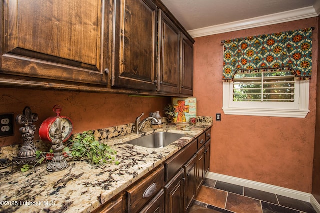 610 N 20th St, Lamesa, TX 79331 - kitchen featuring crown molding, light stone counters, dark brown cabinetry, and stone tile floors
