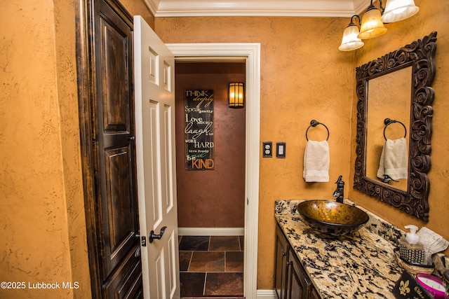 610 N 20th St, Lamesa, TX 79331 - bathroom featuring vanity, stone tile flooring, and crown molding
