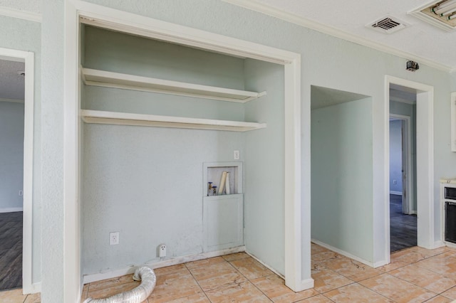 laundry area featuring hookup for a washing machine, ornamental molding, and light tile patterned flooring