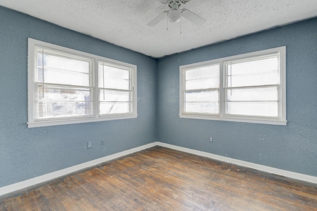 empty room with ceiling fan, dark hardwood / wood-style floors, and a textured ceiling