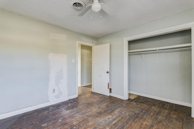 unfurnished bedroom with ceiling fan, dark hardwood / wood-style floors, a textured ceiling, and a closet